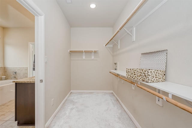 spacious closet featuring light colored carpet