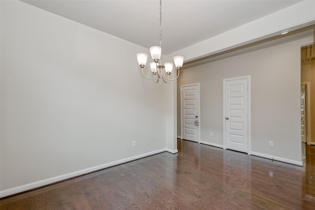 unfurnished room featuring dark hardwood / wood-style flooring and a chandelier