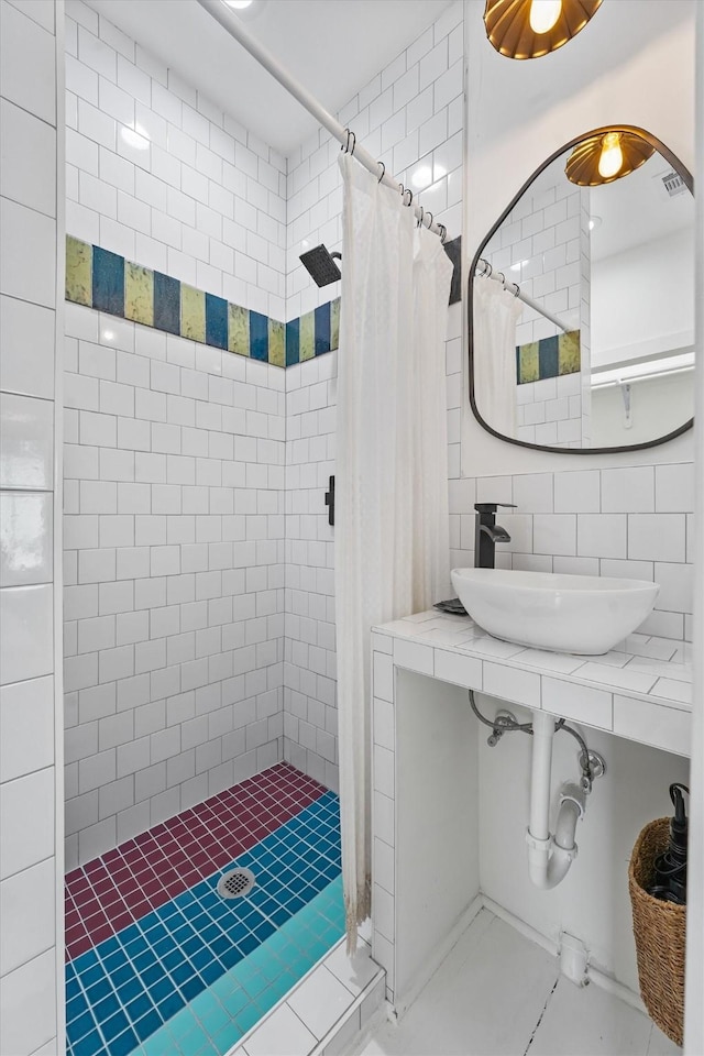 bathroom with walk in shower, sink, tile walls, and decorative backsplash