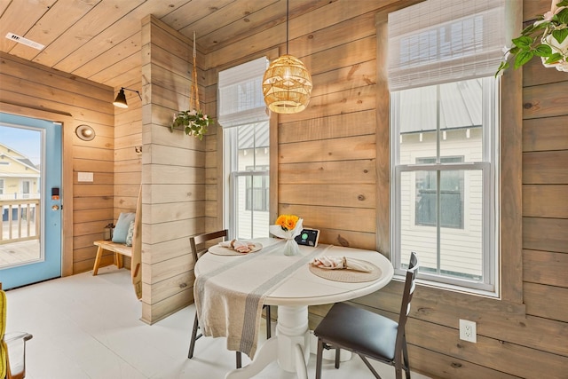 dining room with wood ceiling and wood walls