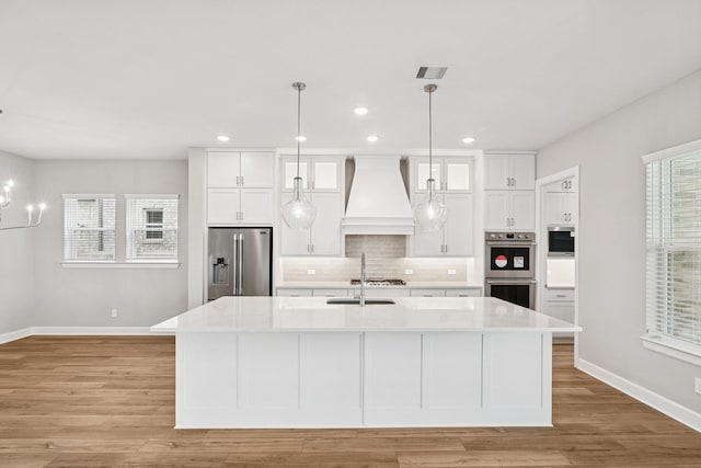 20406 Magnolia Flint Dr, Cypress, TX 77433 - kitchen with appliances with stainless steel finishes, premium range hood, white cabinetry, light countertops, and recessed lighting