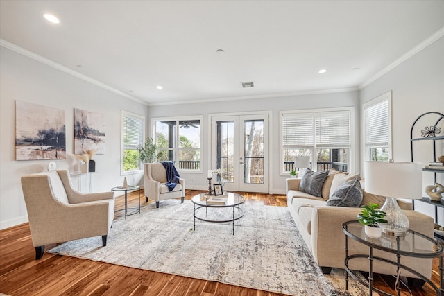 living room with crown molding, hardwood / wood-style floors, and french doors