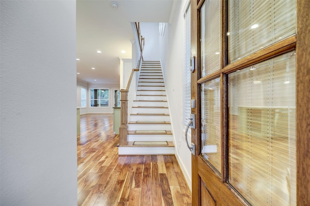 stairway featuring ornamental molding and hardwood / wood-style floors