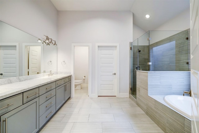 full bathroom with vaulted ceiling, shower with separate bathtub, vanity, and toilet