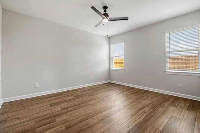 empty room with hardwood / wood-style floors and ceiling fan