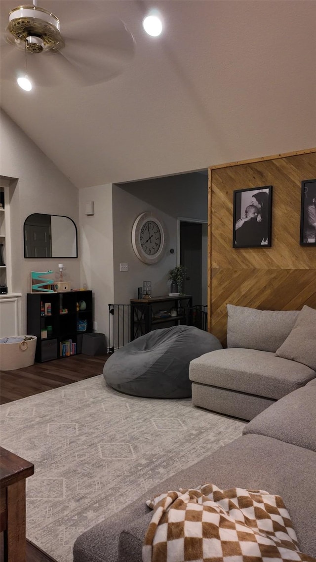 living room featuring lofted ceiling, hardwood / wood-style floors, and wood walls