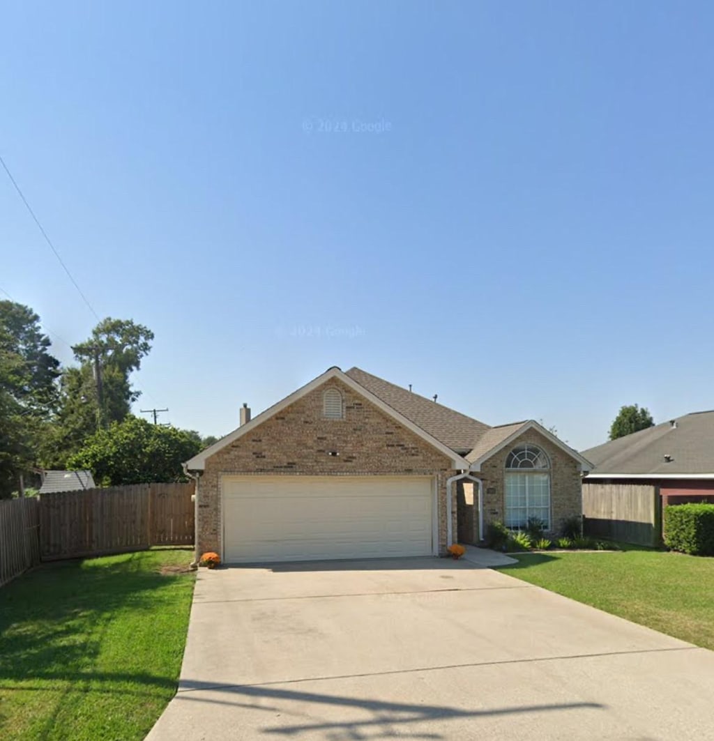 single story home with a garage and a front lawn