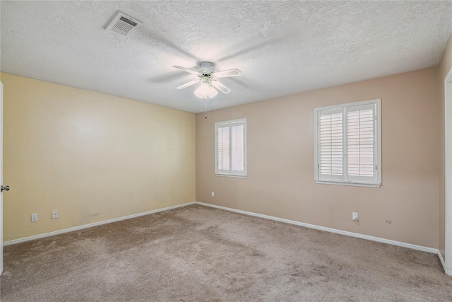 carpeted spare room with a textured ceiling and ceiling fan