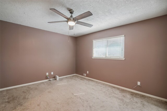 carpeted spare room with ceiling fan and a textured ceiling