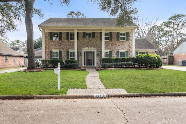 view of front of property with central AC unit and a front yard