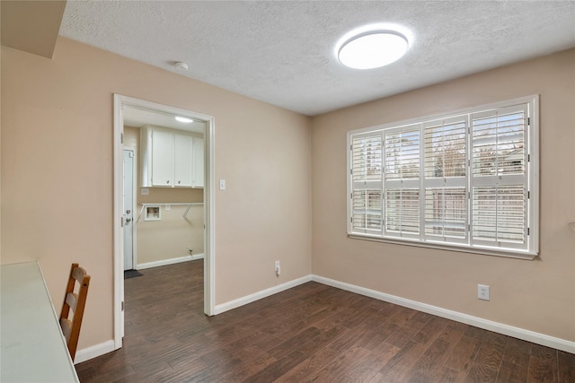 unfurnished dining area with dark hardwood / wood-style floors and a textured ceiling