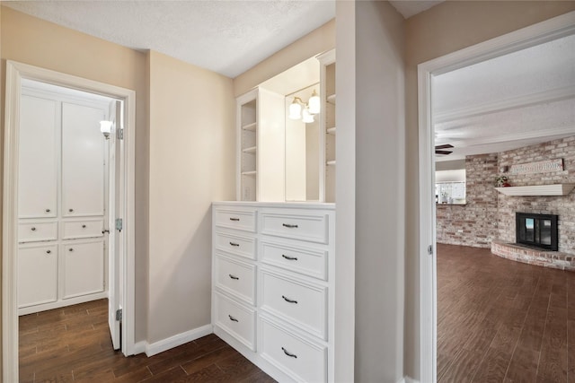 corridor with dark hardwood / wood-style floors and a textured ceiling