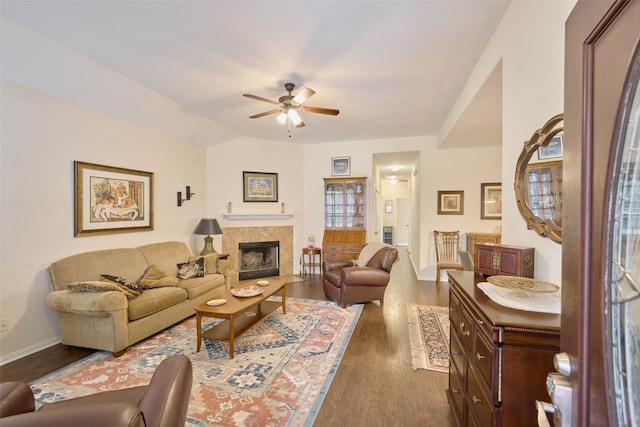 living room featuring a fireplace, ceiling fan, vaulted ceiling, and dark hardwood / wood-style floors