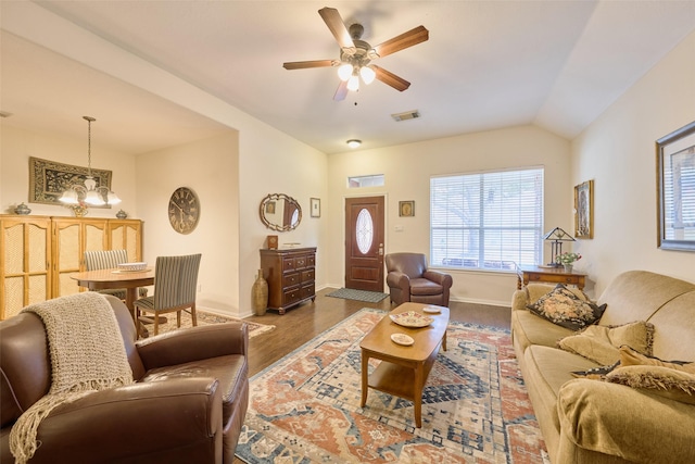 living room featuring ceiling fan with notable chandelier, vaulted ceiling, and hardwood / wood-style flooring