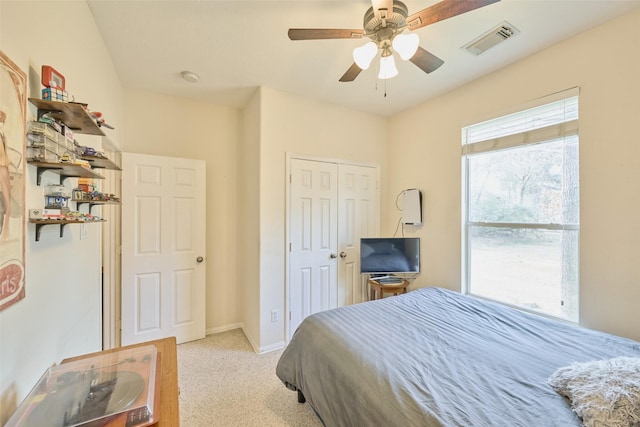 bedroom with a closet, light colored carpet, and ceiling fan