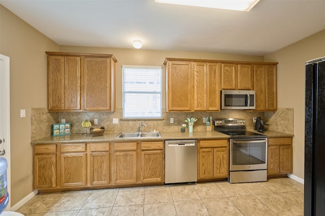 kitchen with sink, backsplash, appliances with stainless steel finishes, and light tile patterned flooring