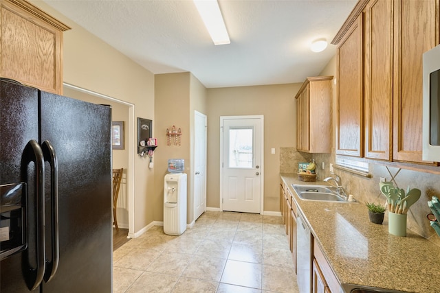 kitchen featuring white dishwasher, black fridge with ice dispenser, decorative backsplash, light tile patterned floors, and sink