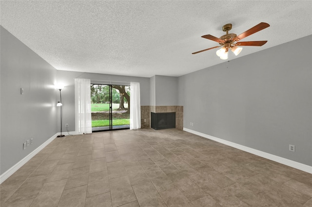 unfurnished living room featuring ceiling fan, a tile fireplace, and a textured ceiling