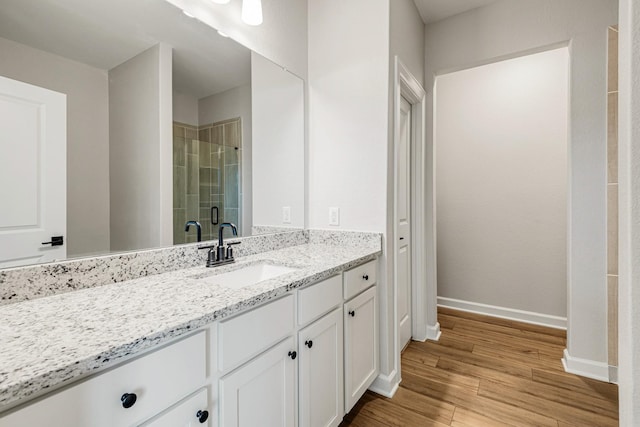 bathroom featuring vanity, hardwood / wood-style floors, and a shower with shower door