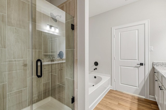 bathroom featuring vanity, separate shower and tub, and wood-type flooring