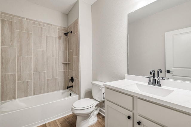 full bathroom with vanity, tiled shower / bath combo, wood-type flooring, and toilet