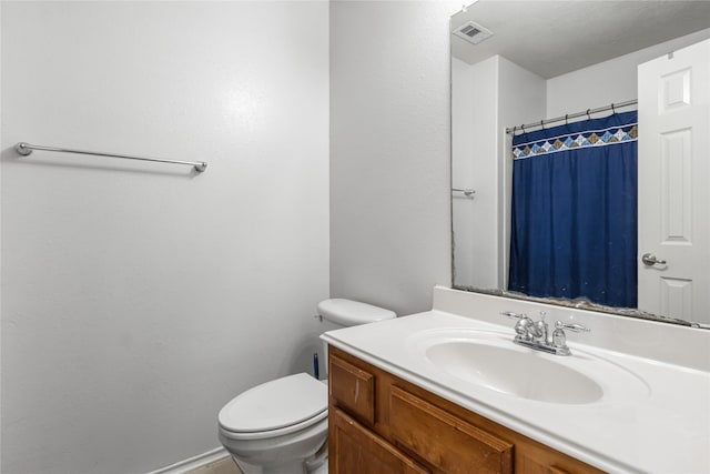 bathroom with vanity, curtained shower, and toilet