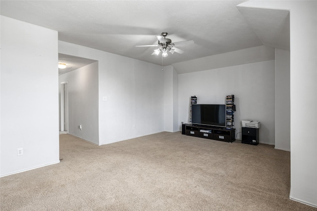 unfurnished living room with ceiling fan, light colored carpet, and vaulted ceiling