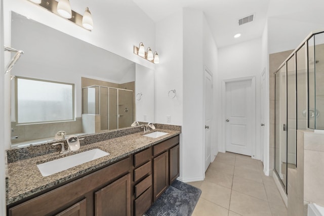 bathroom featuring tile patterned flooring, vanity, and a shower with door