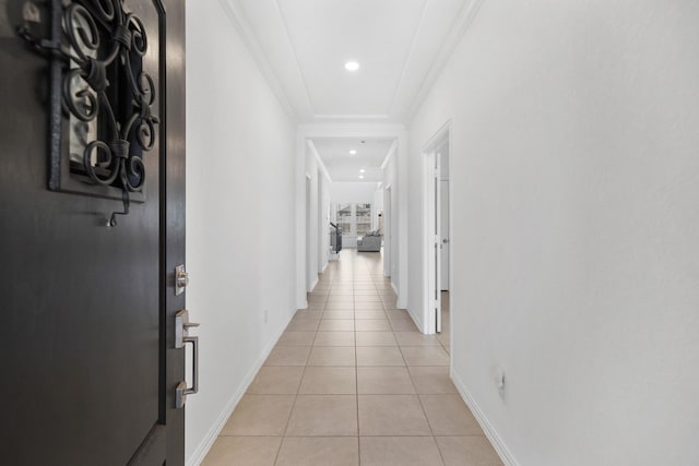 hallway with crown molding and light tile patterned floors