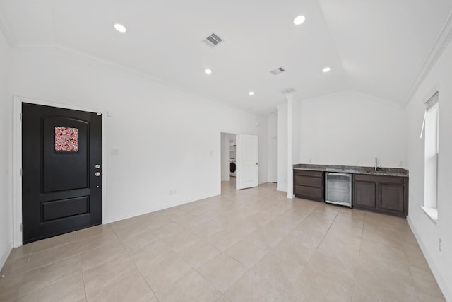 interior space with lofted ceiling, sink, wine cooler, crown molding, and dark brown cabinets