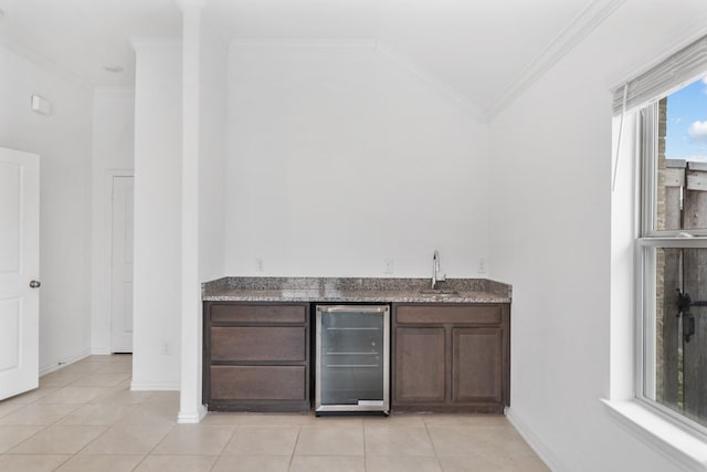 bar with ornamental molding, dark brown cabinets, and wine cooler