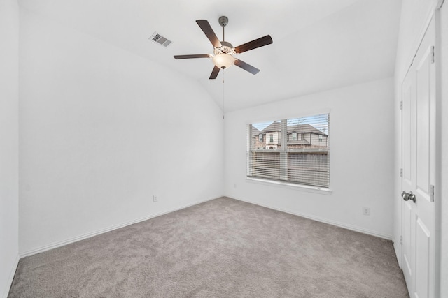 empty room with vaulted ceiling, light colored carpet, and ceiling fan