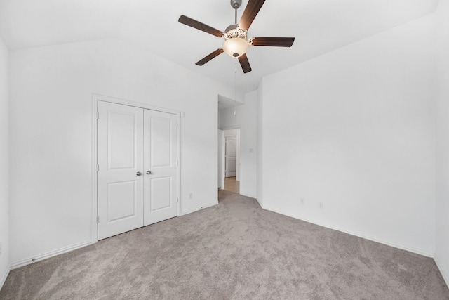 unfurnished bedroom with lofted ceiling, light carpet, ceiling fan, and a closet