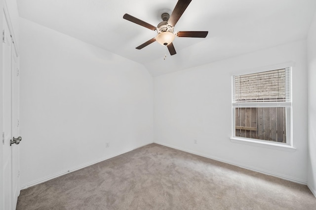 carpeted spare room featuring lofted ceiling and ceiling fan