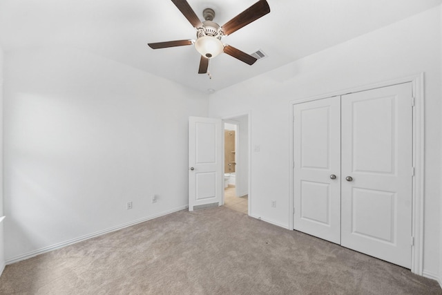 unfurnished bedroom featuring light colored carpet, ceiling fan, and a closet