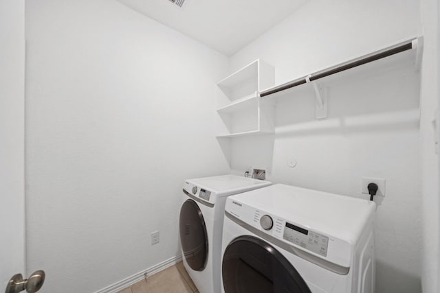 washroom with light tile patterned floors and washer and dryer