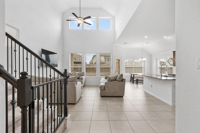 living room with sink, light tile patterned floors, ceiling fan with notable chandelier, and vaulted ceiling