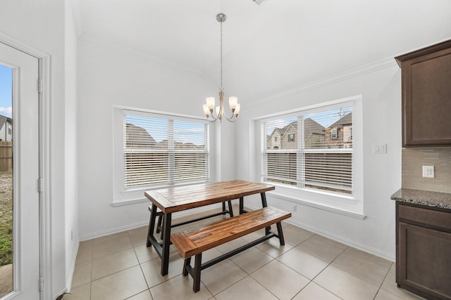 dining room with crown molding, a chandelier, and light tile patterned floors