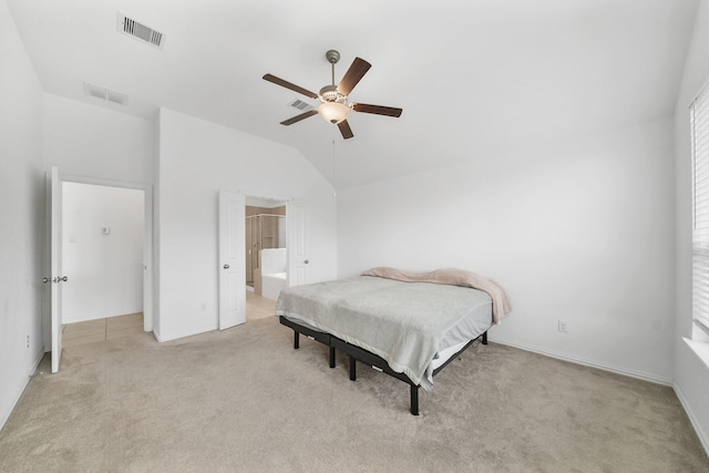 carpeted bedroom with ceiling fan, lofted ceiling, and ensuite bath