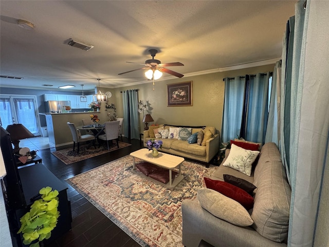 living room featuring crown molding, ceiling fan, wood-type flooring, and a textured ceiling