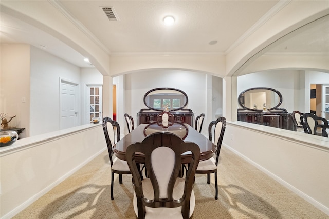 dining space with crown molding and light carpet