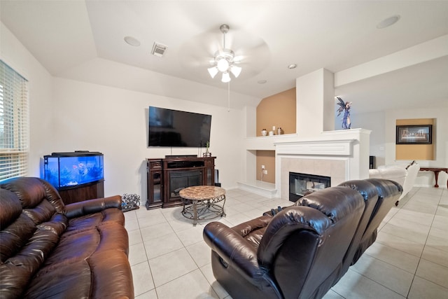 tiled living room with ceiling fan and a tile fireplace