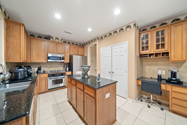 kitchen featuring sink, light tile patterned floors, dark stone countertops, a kitchen island, and stainless steel appliances