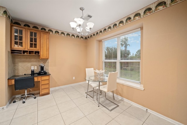 home office featuring light tile patterned flooring, built in desk, and a notable chandelier