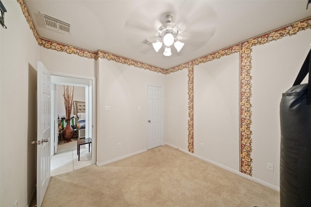 carpeted spare room featuring ceiling fan