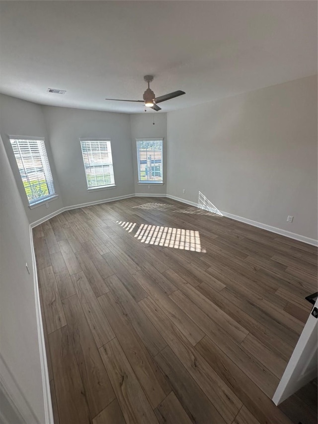 unfurnished room featuring dark wood-type flooring and ceiling fan