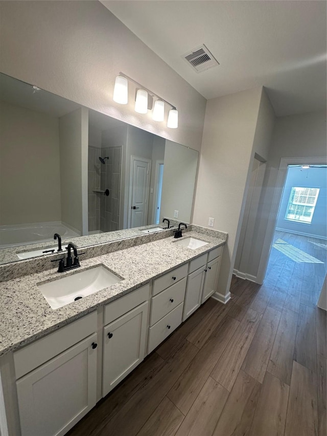 bathroom featuring vanity, hardwood / wood-style floors, and walk in shower