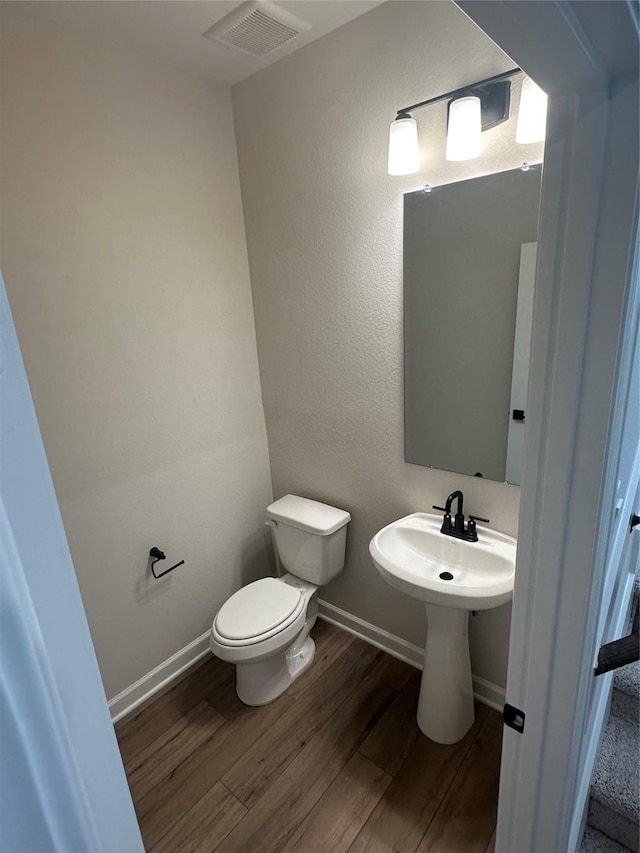 bathroom featuring wood-type flooring and toilet