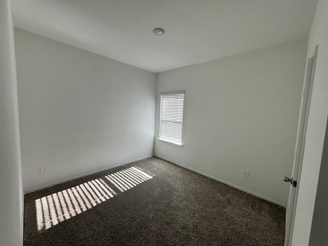 empty room featuring dark carpet