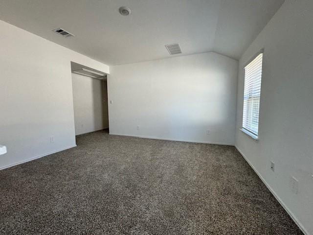 carpeted empty room with lofted ceiling